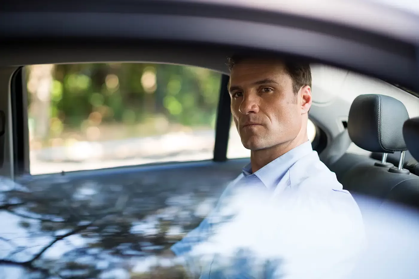 Photo of a man sitting in car's back seat